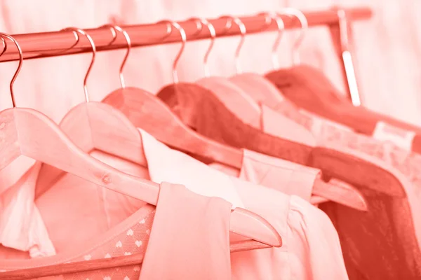 Korall kvinnors kläder på galgar på rack i modebutik. garderob — Stockfoto