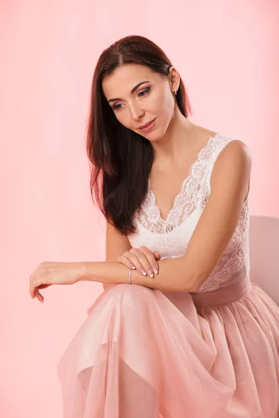 Charming woman in pink lush skirt on pink background. — Stock Photo, Image