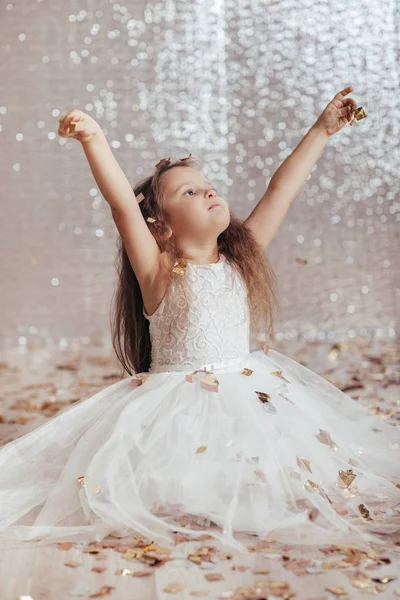 Маленька дівчинка в сукні принцеси на фоні конфетті — стокове фото
