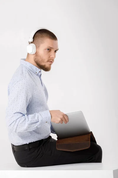 Hombre de negocios en auriculares pone portátil en la cubierta — Foto de Stock