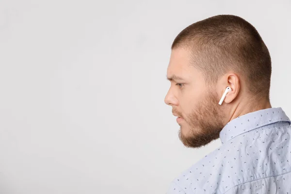 Kalm bebaarde jonge zakenman maakt gebruik van draadloze hoofdtelefoons. — Stockfoto