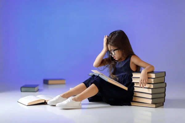 Linda niña está leyendo un libro . —  Fotos de Stock