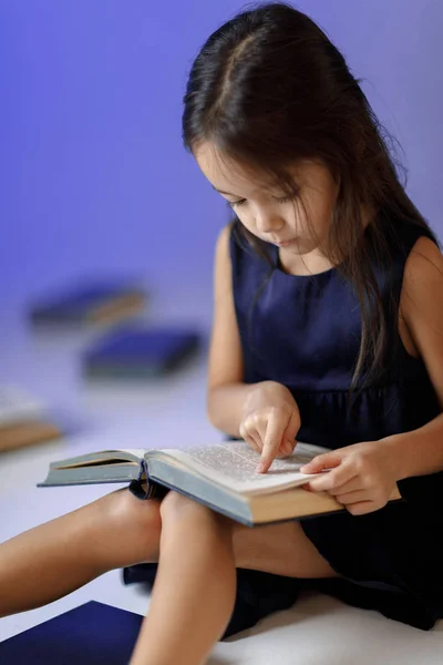 Schattig klein meisje is het lezen van een boek. — Stockfoto