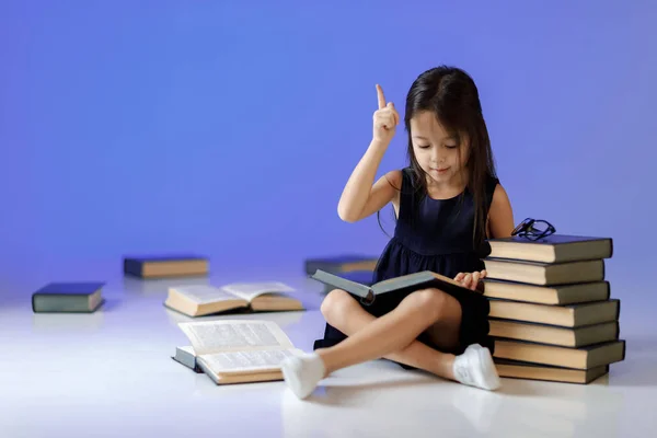 Menina bonito está lendo um livro . — Fotografia de Stock