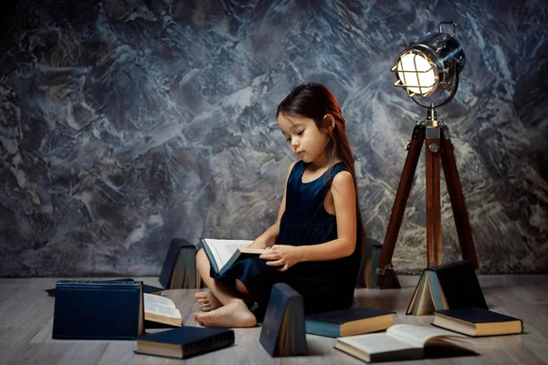 Menina bonito está lendo um livro . — Fotografia de Stock