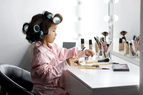 Niedliches kleines Mädchen spielt mit ihren Müttern Kosmetik — Stockfoto