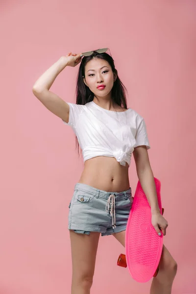 Schöne asiatische Frau mit Sonnenbrille und Skateboard — Stockfoto