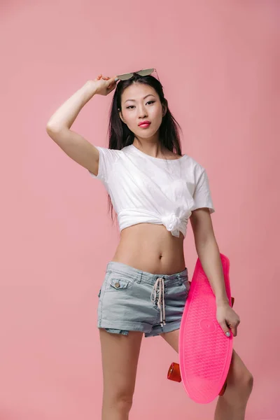 Beautiful asian woman in sunglasses with skateboard — Stock Photo, Image