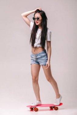 güzel Asyalı kadın güneş gözlüğü kaykay ile