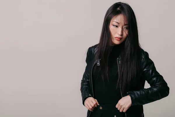 Азиатская модель в черной куртке позирует в студии — стоковое фото