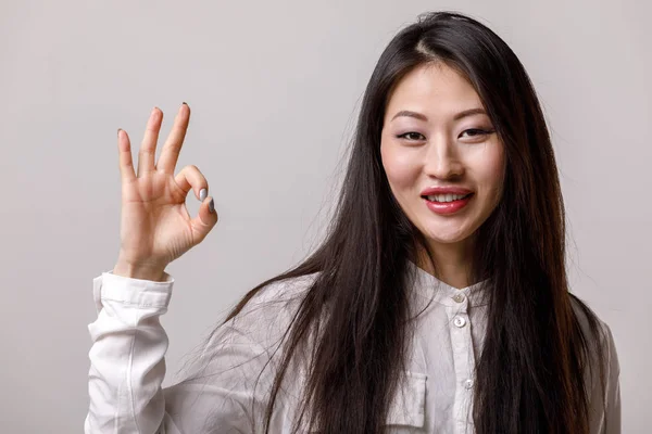 Asiatische Frau in Brille und weißem Hemd zeigt Geste ok — Stockfoto