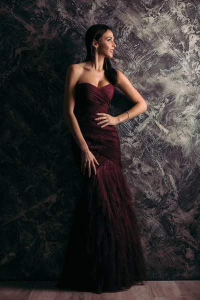 Abiye koyu arka plan üzerinde poz kadında