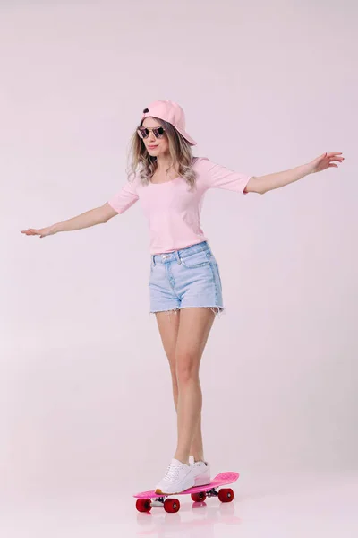 Όμορφη γυναίκα στο λευκό t-shirt με ροζ skateboard — Φωτογραφία Αρχείου