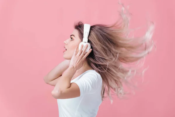 Όμορφη ξανθιά γυναίκα στο λευκό ακουστικά ακούει μουσική — Φωτογραφία Αρχείου