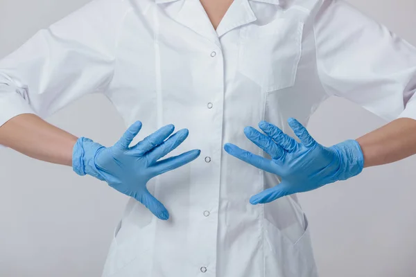 Kvinna läkare händerna i medicinsk latex blå handskar — Stockfoto