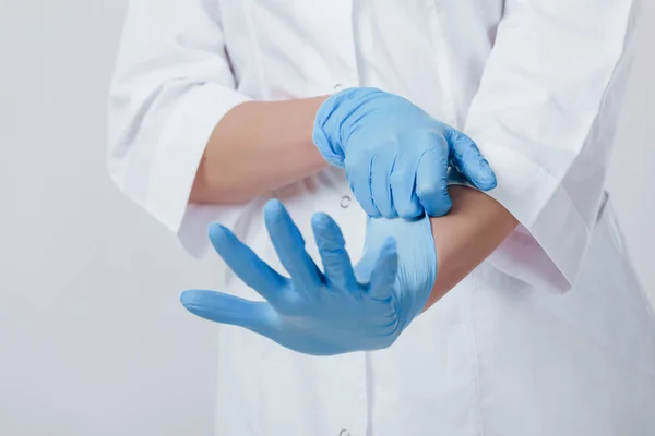 Kvinna läkare händerna i medicinsk latex blå handskar — Stockfoto
