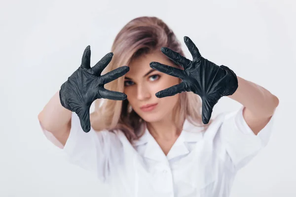 woman doctor in black medical gloves shows stop sign