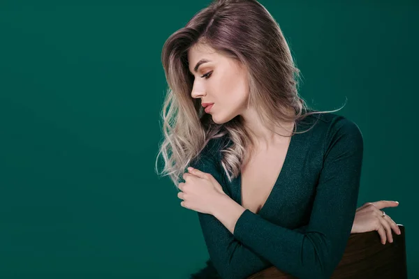 Blonde woman posing in green dress on green background — Stock Photo, Image