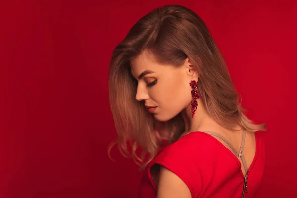 Blonde woman posing in red dress on red background — Fotografie, imagine de stoc