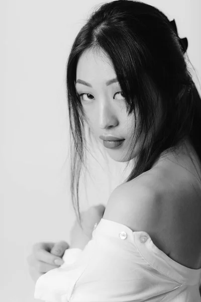 Hermosa asiático mujer en blanco camisa posando en estudio . — Foto de Stock