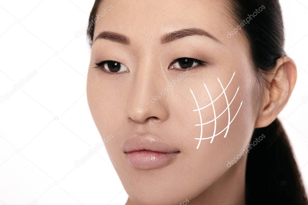 Spa portrait of attractive asian woman with arrows on her face