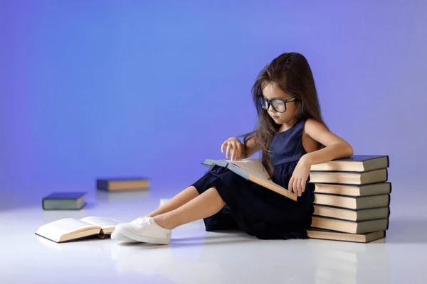Roztomilá holčička čte knihu. — Stock fotografie