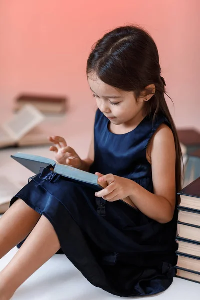 Söt liten flicka läser en bok. — Stockfoto