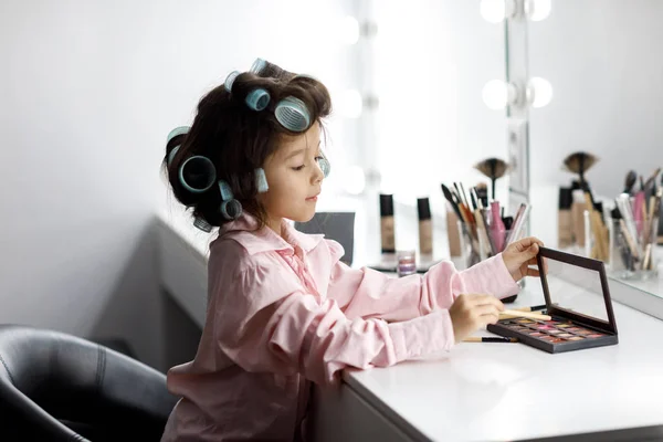 Schattig klein meisje speelt met haar moeders cosmetische — Stockfoto