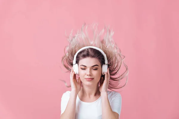 Beautiful blonde woman in white headphones listens to music — Stock Photo, Image
