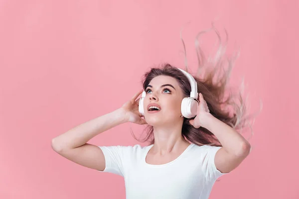 Όμορφη ξανθιά γυναίκα στο λευκό ακουστικά ακούει μουσική — Φωτογραφία Αρχείου