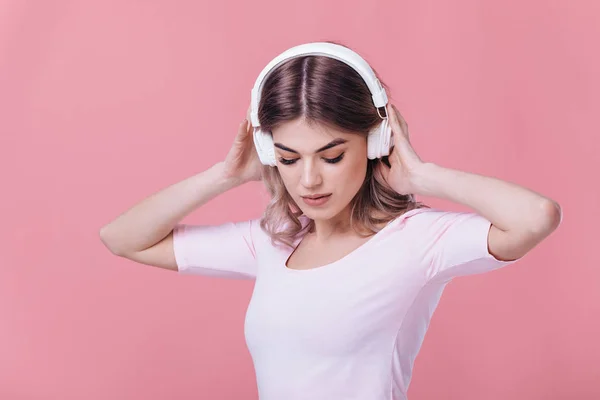 Beautiful blonde woman in white headphones listens to music — Stock Photo, Image