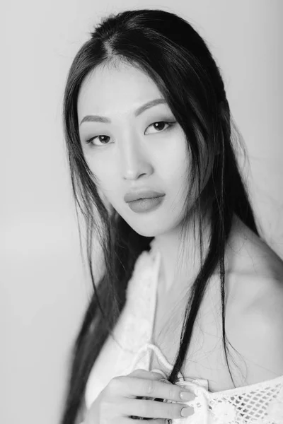 Beautiful asian woman in white shirt posing in studio. — Stock Photo, Image