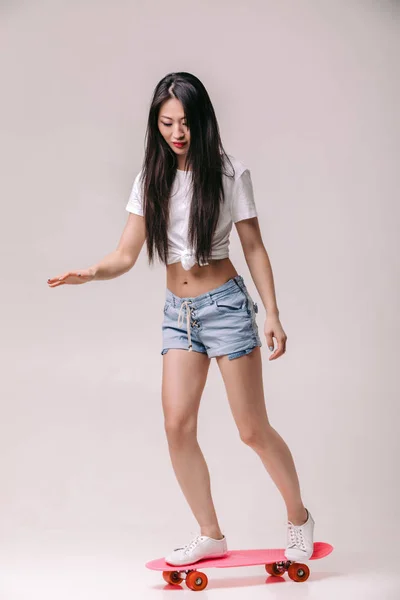 Vacker asiatisk kvinna i solglasögon med skateboard — Stockfoto