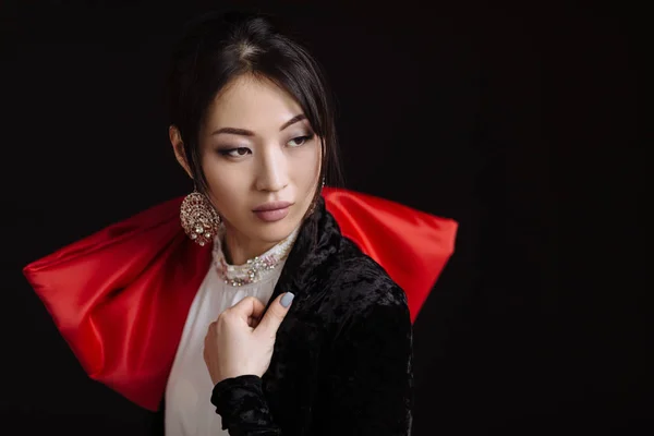 Asian woman with gold earrings and big red bow — Stock Photo, Image