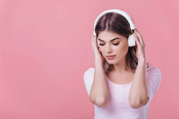 Beautiful blonde woman in white headphones listens to music — Stock Photo, Image