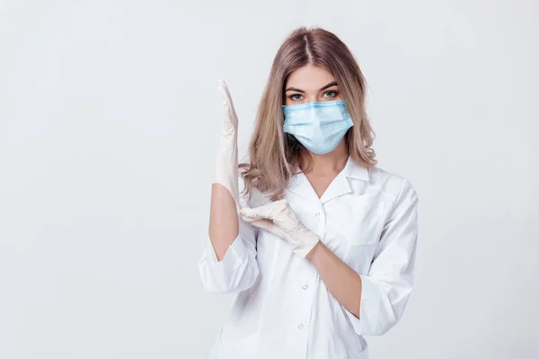 Kvinna läkare med ansiktsmask och medicinska handskar — Stockfoto