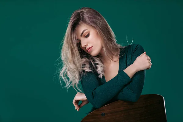 Blondine posiert in grünem Kleid auf grünem Hintergrund — Stockfoto