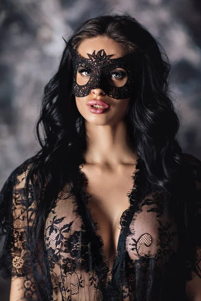 Porträt einer sexy schönen Frau in Spitzenunterwäsche und Karnevalsmaske — Stockfoto