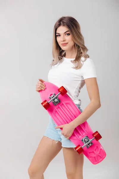 분홍색 스케이트 보드와 흰색 티셔츠에 아름 다운 여자 — 스톡 사진