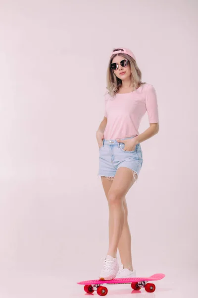 Όμορφη γυναίκα στο λευκό t-shirt με ροζ skateboard — Φωτογραφία Αρχείου