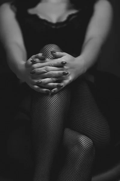 Стройная сексуальная женщина в черных чулках сидит на стуле — стоковое фото