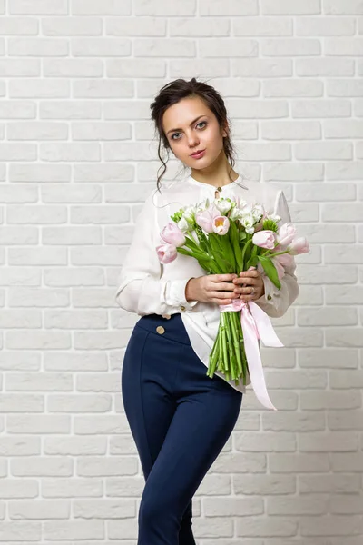 Schöne brünette Frau mit einem Strauß Tulpenblumen — Stockfoto