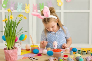 Paskalya yumurtaları evde boyama Paskalya tavşan kulaklı kız küçük çocuk.