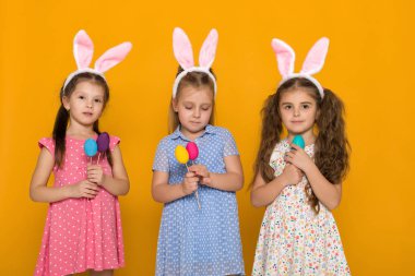 renkli yumurta tutan Paskalya tavşan kulaklı küçük kızlar