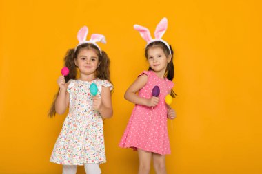 renkli yumurta tutan Paskalya tavşan kulaklı küçük kızlar