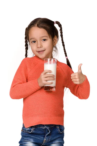 Маленька дівчинка тримає склянку молока на білому тлі — стокове фото