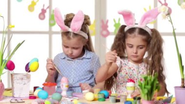 Mutlu çocuk yumurta Paskalya gününde boyama tavşan kulakları giyiyor.
