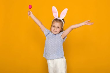 Paskalya tavşan kulakları renkli yumurta holding ile sevimli küçük kız