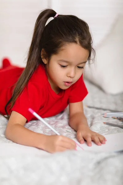 Lilla barn flicka dragningar med pennor hemma — Stockfoto