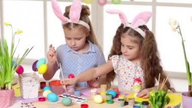 Mutlu çocuk yumurta Paskalya gününde boyama tavşan kulakları giyiyor.